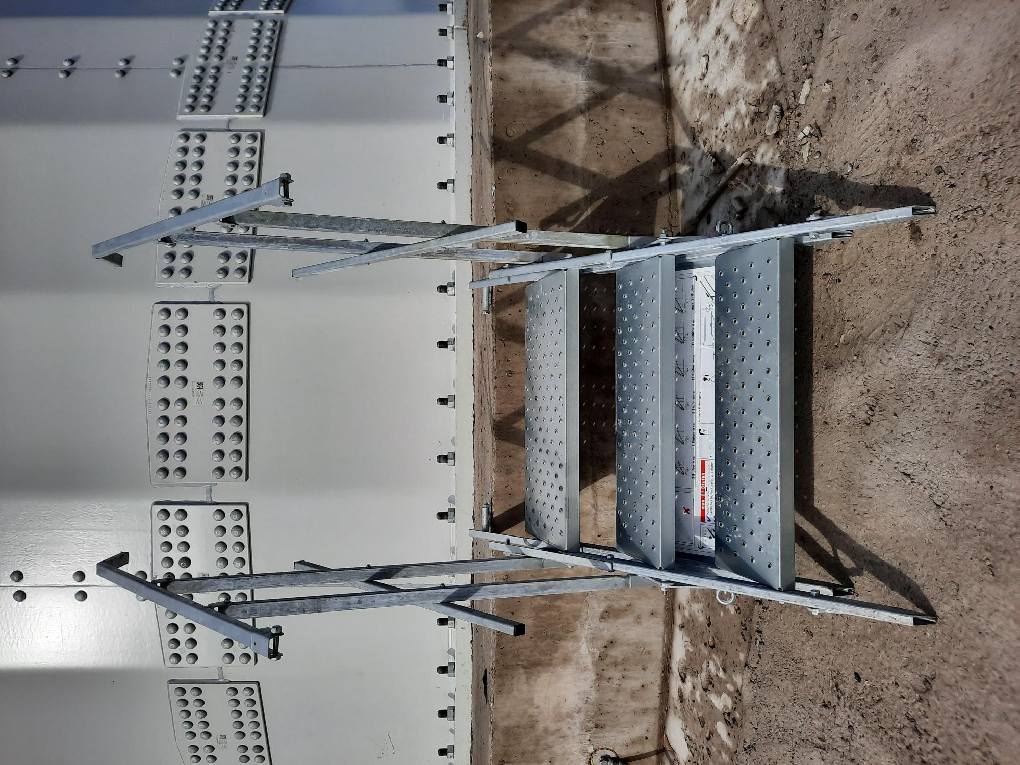 Frontansicht der dreistufigen MÜBA Bautreppe am erhöhten Betonabsatz der Windkraftanlage